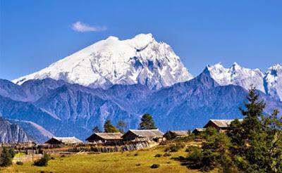 A beautiful scene of residences seen with snow capped mountains in the background of Khakaborazi National Park.